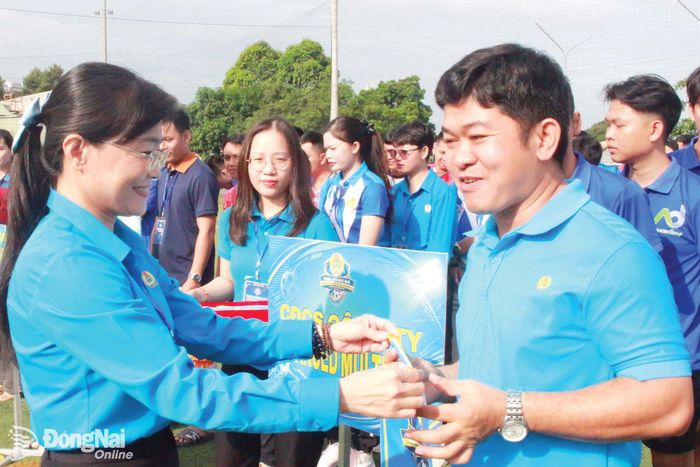 Phó Chủ tịch Liên đoàn Lao động thành phố Bùi Thị Bích Thủy trao cờ lưu niệm cho các đội tham gia Giải bóng đá công nhân, viên chức, lao động năm 2026. Ảnh: Nguyễn Hòa