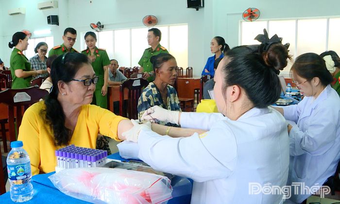 Thân nhân liệt sĩ chưa xác định được danh tính lấy mẫu sinh phẩm tại điểm phường Mỹ Tho.