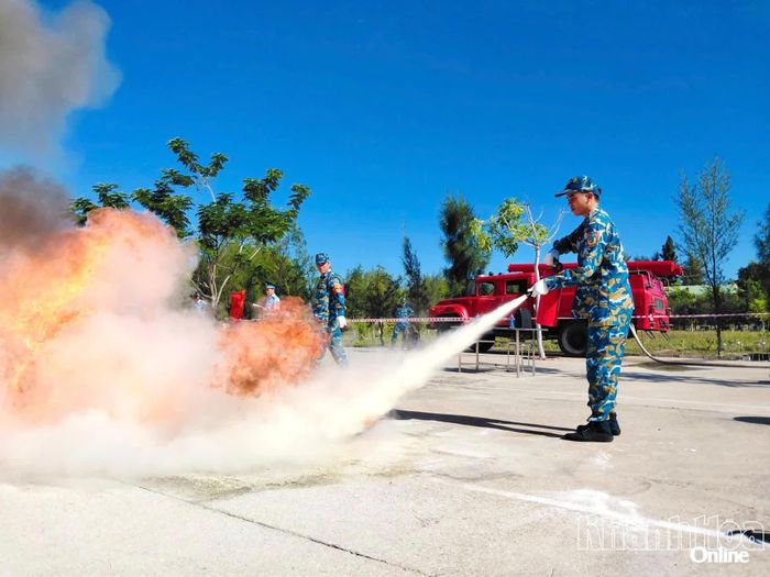 Các vận động viên thực hành nội dung dùng bình chữa cháy dập tắt đám cháy khay xăng.