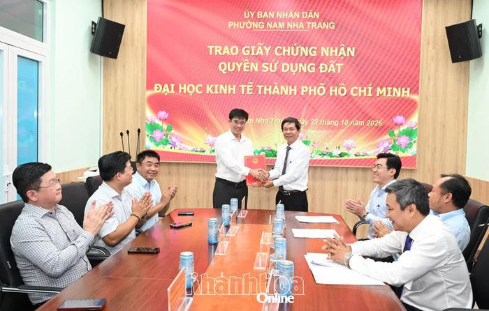 Ông Nguyễn Văn Minh trao giấy chứng nhận quyền sử dụng đất cho Phó Giáo sư, Tiến sĩ Bùi Quang Hùng, đại diện cho Đại học Kinh tế TP. Hồ Chí Minh.