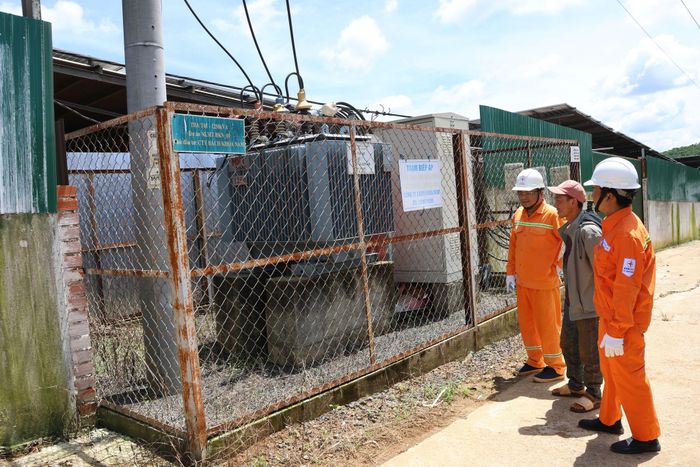 Nhân viên Điện lực kiểm tra trạm biến áp tại trang trại heo có sử dụng điện mái nhà bảo đảm an toàn