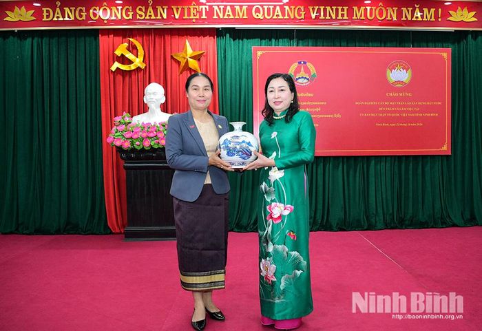 Đồng chí Đinh Thị Lụa, Phó Bí thư Tỉnh ủy, Chủ tịch Ủy ban MTTQ Việt Nam tỉnh tặng quà lưu niệm cho đại diện Đoàn cán bộ Mặt trận Lào xây dựng đất nước.