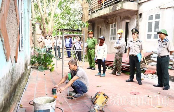 Lực lượng chức năng đo đạc, tháo dỡ phần công trình phụ nhà cấp 4 xây lấn sang thửa đất số 40-1, tờ bản đồ số 27, trả lại cho ông Dương Mạnh Hùng diện tích đất 1,8m