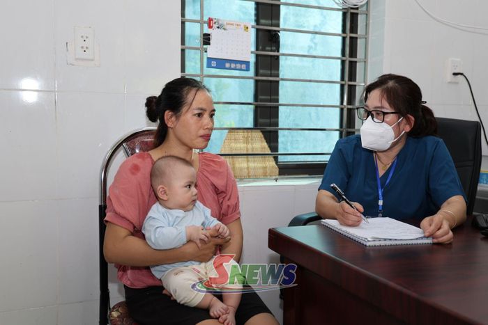 Cán bộ Trạm y tế xã Tạ Khoa kiểm tra thông tin, lịch sử tiêm chủng của trẻ.