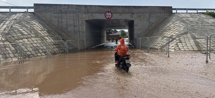 Người dân di chuyển khó khăn qua khu vực ngập.