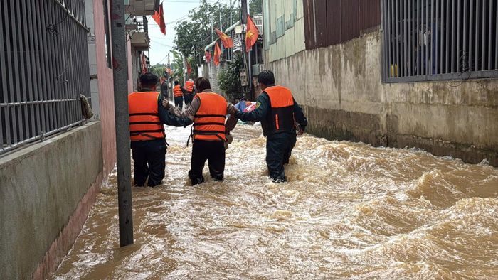 Lực lượng chức năng hỗ trợ đưa người dân đến nơi an toàn.