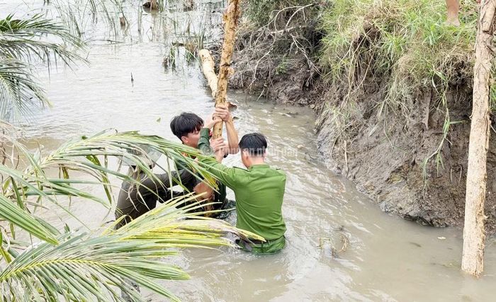 Cán bộ chiến sĩ Công an TP Cần Thơ phối hợp gia cố đê bao bị vỡ, nhằm hạn chế thiệt hại tài sản của người dân.