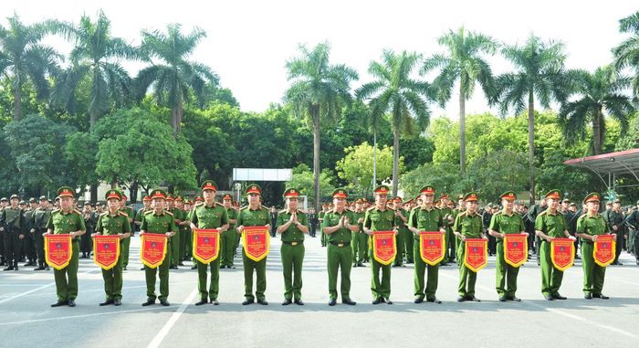 Thiếu tướng Lê Văn Tuân, Phó giám đốc Công an TP Hà Nội trao cờ lưu niệm tặng các đơn vị tham gia hội thi.