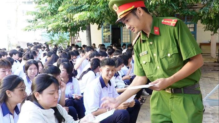 Cán bộ Công an phát tờ rơi cho học sinh Trường THPT Phan Thiết.