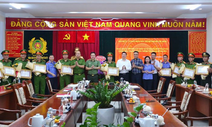 Đồng chí Hoàng Nguyên Dinh - Phó Chủ tịch UBND Thành phố; Trung tướng Mai Hoàng - Giám đốc Công an Thành phố và Thượng tá Nguyễn Thành Hưng - Phó Giám đốc Công an Thành phố trao khen thưởng cho các đơn vị, cá nhân lập thành tích xuất sắc trong đấu tranh chuyên án
