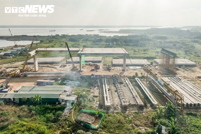 Tại xã Ô Diên, những phiến dầm đầu tiên đang được lắp đặt trên hệ thống trụ cầu cạn. Đây là dấu mốc quan trọng, cho thấy công trình chuyển dần từ giai đoạn thi công nền móng, trụ cầu sang hình thành kết cấu mặt cầu.