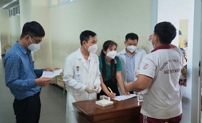 Các học sinh tiếp xúc gần với ca bệnh tại phường Bình Dương được uống kháng sinh dự phòng. (Ảnh: HCDC)