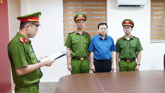 Cơ quan CSĐT đọc quyết định khởi tố bị can đối với ông Hoàng Văn Lộc, Bí thư Đảng ủy, Chủ tịch HĐND xã Hợp Kim. (Ảnh: CAPT)