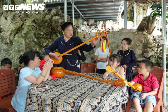 Nghệ nhân Bế Thị Bích Dơ đang hướng dẫn chơi đàn tính cho các bạn nhỏ.
