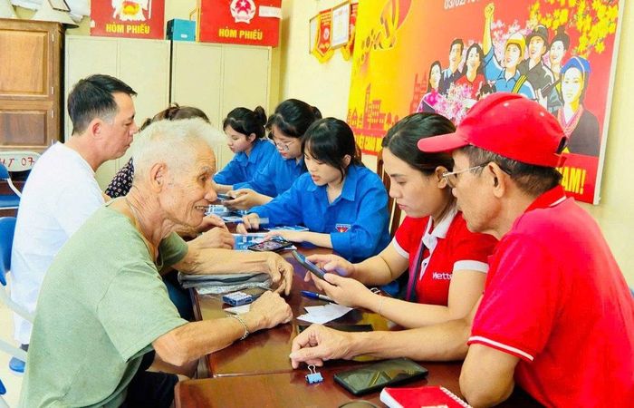 Thành viên Tổ chuyển đổi số cộng đồng xã Hoài Đức hướng dẫn người dân cài đặt và sử dụng ứng dụng công dân Thủ đô số (iHanoi). Ảnh: Hồng Lý