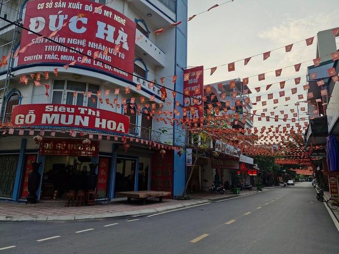 Người dân ở làng nghề mộc cao cấp Vạn Điểm trang trí cờ hoa rực rỡ chào đón Lễ hội vinh danh làng nghề và Tuần lễ quảng bá nông sản- đặc sản vùng miền Hà Nội năm 2026. Ảnh: PV