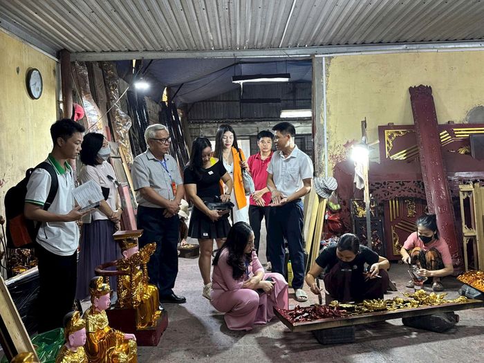 Du khách trải nghiệm các công đoạn điêu khắc, "dát vàng" trên các sản phẩm thủ công. Ảnh: Hoàng Lân