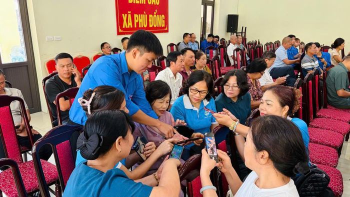 Đoàn viên, thanh niên xã Phù Đổng hướng dẫn người dân tiếp cận các tiện ích số. Ảnh PV