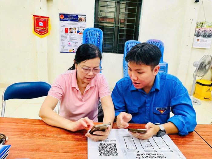 Các bạn trẻ hướng dẫn người dân sử dụng điện thoại thông minh và các nền tảng số. Ảnh PV