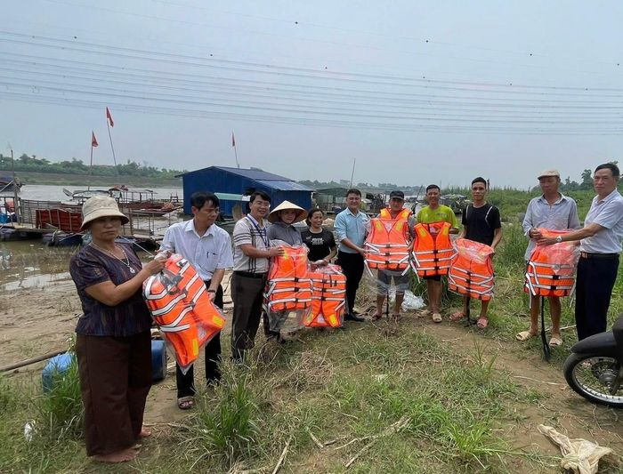 Lãnh đạo Ủy ban MTTQ Việt Nam phường Việt Hưng trao áo phao tới các hộ dân. Ảnh: PV
