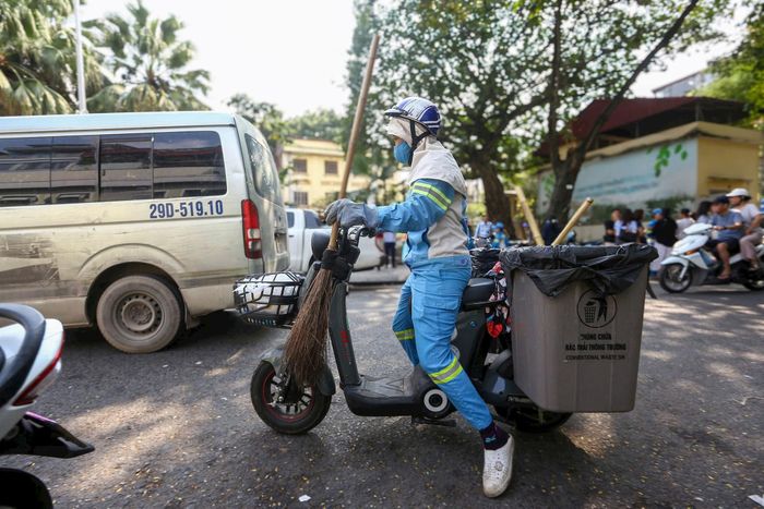 Nữ công nhân môi trường được trang bị bảo hộ và trang thiết bị phục vụ công việc. Ảnh: Khánh Huy