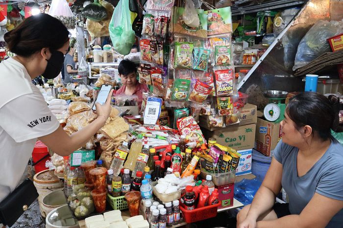 Người dân thanh toán bằng mã QR tại chợ trên địa bàn phường Thanh Xuân. Ảnh: Tùng Lâm