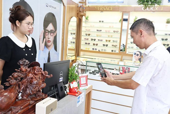 Người dân thanh toán bằng mã QR tại một điểm kinh doanh trên địa bàn phường Thanh Xuân. Ảnh: Tùng Lâm