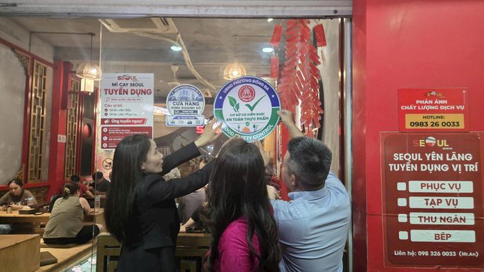 Lãnh đạo phường Đống Đa gắn biển cơ sở có kiểm soát an toàn thực phẩm trên phố Yên Lãng. Ảnh: Đỗ Hưng