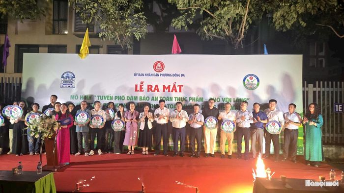 Lãnh đạo phường Đống Đa trao logo nhận diện “Cơ sở có kiểm soát an toàn thực phẩm” cho đại diện 14 cơ sở kinh doanh trên phố Yên Lãng. Ảnh: Đỗ Hưng
