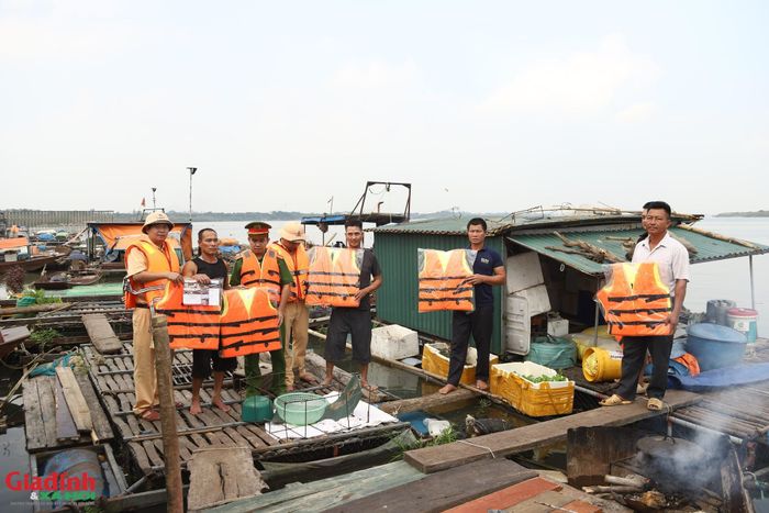Tổ công tác trao tặng áo phao cứu sinh cho người dân để bảo đảm an toàn giao thông đường thủy.