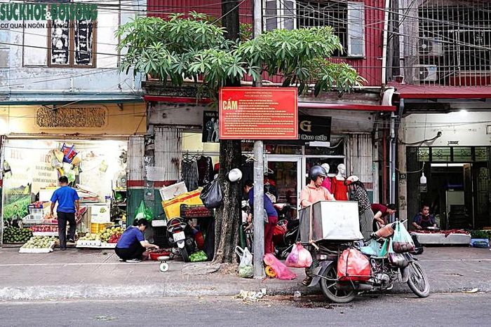 Ghi nhận sáng 22/10, chợ tự phát trên phố Cầu Mới, Đống Đa, Hà Nội, vẫn bày bán rau, cá, thực phẩm,... tràn ra vỉa hè, lòng đường dù đã có biển cấm. (Ảnh Linh Vũ)