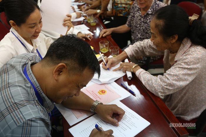 Người dân kiểm tra thông tin, ký xác nhận hồ sơ nhận tiền bồi thường. Ảnh: Tuấn Anh