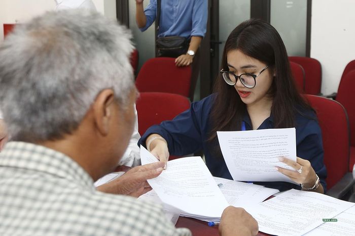 Cán bộ, nhân viên hướng dẫn người dân hoàn thiện thủ tục. Ảnh: Tuấn Anh
