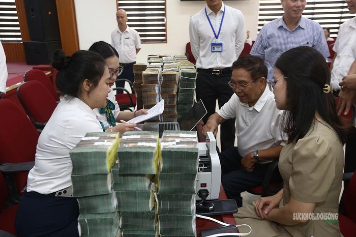 Người dân được tư vấn, hỗ trợ thực hiện giao dịch ngân hàng ngay tại buổi chi trả. Ảnh: Tuấn Anh