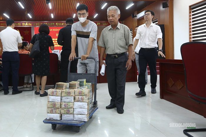 Những cọc tiền mặt được vận chuyển phục vụ công tác chi trả bồi thường cho người dân. Ảnh: Tuấn Anh