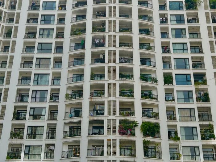 Giữa hàng trăm ô ban công giống nhau, sắc hoa giấy rực rỡ hòa quyện cùng những vạt cây xanh rủ xuống thể hiện những phong cách sống khác nhau của mỗi hộ dân