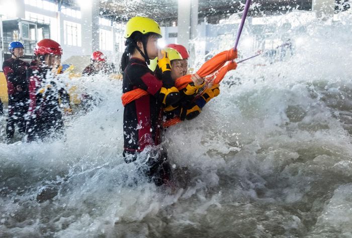  Các thành viên chuẩn bị đối mặt với dòng nước dâng cao trong một mô phỏng lũ quét tại trung tâm Lvxing ở Hàng Châu. Ảnh: Reuters. 