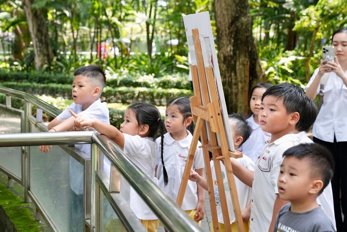 Các em học sinh Trường mầm non Angels Garden Montessori tò mò về chú sư tử trắng ở Thảo Cầm Viên.