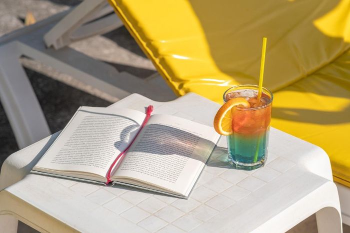 Du khách thư giãn bên ly cocktail mát lạnh và cuốn sách yêu thích trên bãi biển đầy nắng ở Antalya, Thổ Nhĩ Kỳ. Ảnh: Yasir YETER/Pexels.