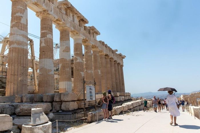 Khách du lịch che ô tránh nắng nóng tại Athens, Hy Lạp, ngày 25/8/2026. Ảnh: THX/TTXVN phát