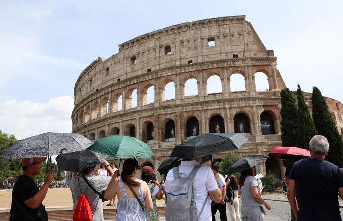 Khách du lịch che ô tránh nắng nóng tại Rome, Italy, ngày 26/8/2026. Ảnh: THX/TTXVN phát