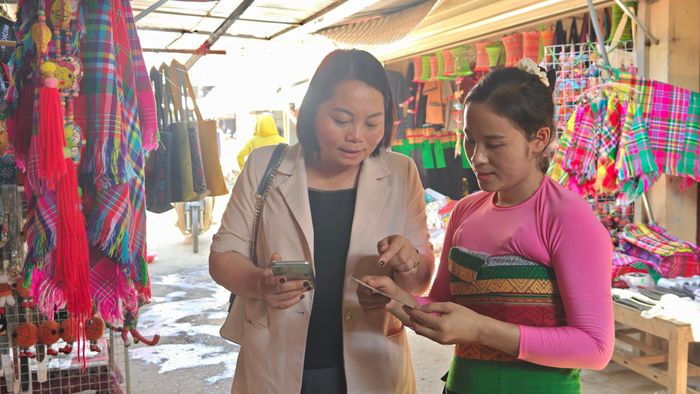 Bà Bùi Thị Hoa hỏi thăm chị Hà Thị Giáo về mã QR. Ảnh: Huy Thông