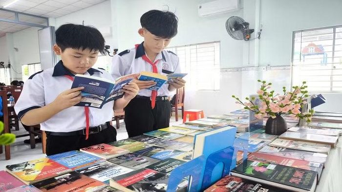 Học sinh xã Thạnh Phong tìm hiểu thông tin về đường Hồ Chí Minh trên biển. (Ảnh: HOÀNG TRUNG)