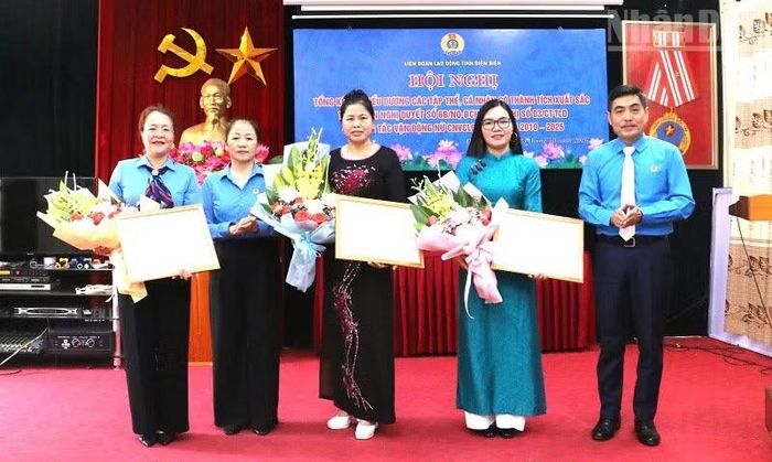 Đồng chí Tẩn Minh Long, Chủ tịch Liên đoàn Lao động tỉnh Điện Biên trao bằng khen tặng các tập thể có nhiều đóng góp trong vận động nữ công nhân, viên chức, lao động tham gia phong trào. (Ảnh: LÊ LAN)