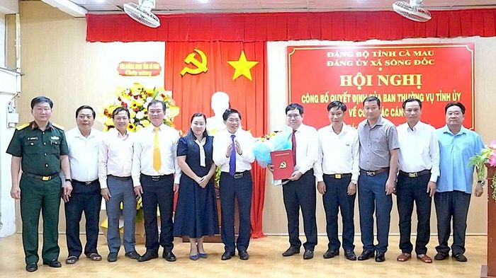Phó Bí thư Thường trực Tỉnh ủy Cà Mau Đặng Văn Dũng (thứ 6 từ trái qua), cùng các đồng chí trong Ban Thường vụ Đảng ủy xã Sông Đốc chúc mừng tân Bí thư Đảng ủy xã Sông Đốc Lê Văn Ngời. (Ảnh: TIỆP KHẮC)