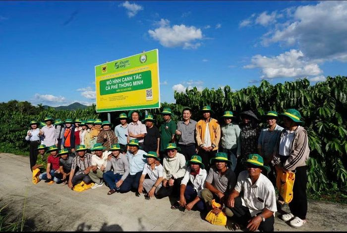 Đại biểu, nhà khoa học và nông dân chụp ảnh lưu niệm trước bảng mô hình Canh tác cà-phê thông minh tại Đắk Hà.(Ảnh: HỒ HUY)