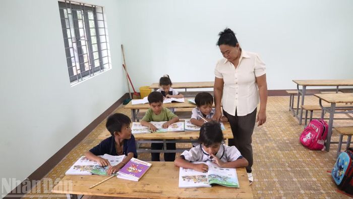 Cô giáo hướng dẫn học sinh lớp 1 học bài. (Ảnh: CÔNG LÝ)