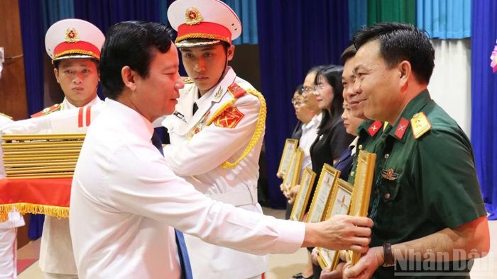 Phó Chủ tịch Ủy ban nhân dân tỉnh Tây Ninh Phạm Tấn Hòa tặng bằng khen của Chủ tịch cho tập thể và cá nhân có thành tích xuất sắc trong công tác tìm kiếm, quy tập và xác định danh tính hài cốt liệt sĩ. (Ảnh THANH PHONG)