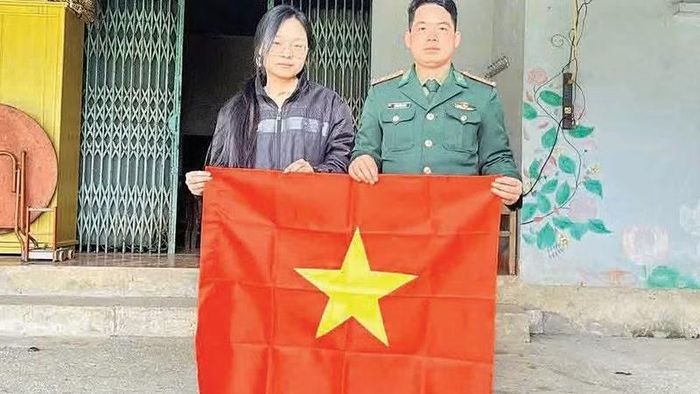 Cán bộ, chiến sĩ Đồn Biên phòng Xuân Trường tặng cờ Tổ quốc cho người dân ở xóm biên giới.