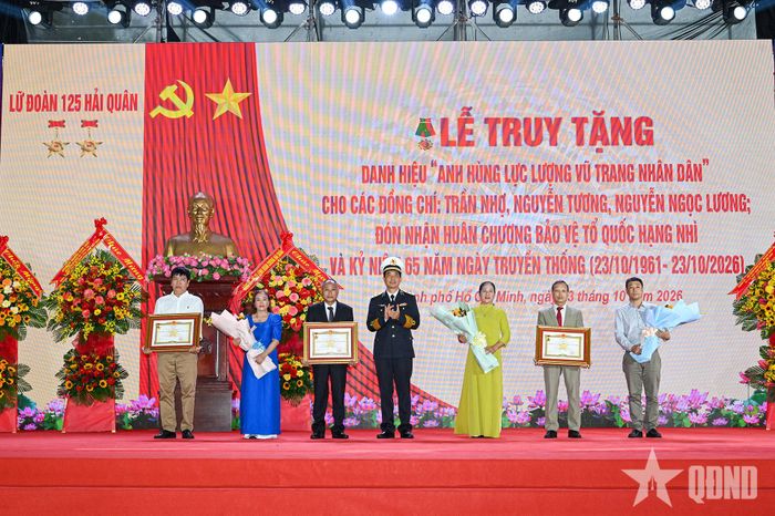 Thừa ủy quyền của Chủ tịch nước, Phó đô đốc Nguyễn An Phong trao bằng danh hiệu Anh hùng LLVT nhân dân cho gia đình các liệt sĩ.